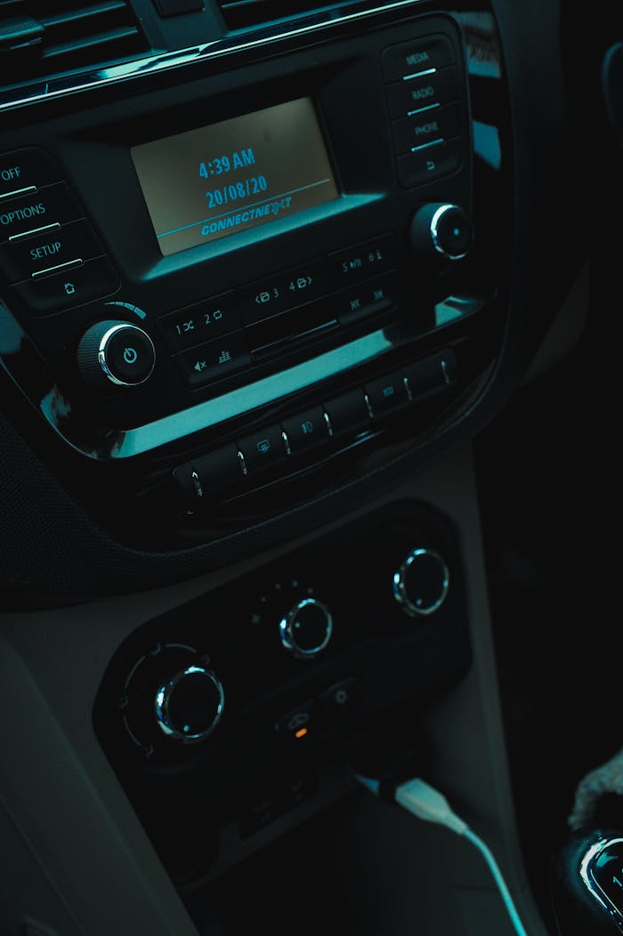 Car dashboard showing stereo and control panel with illuminated display.
