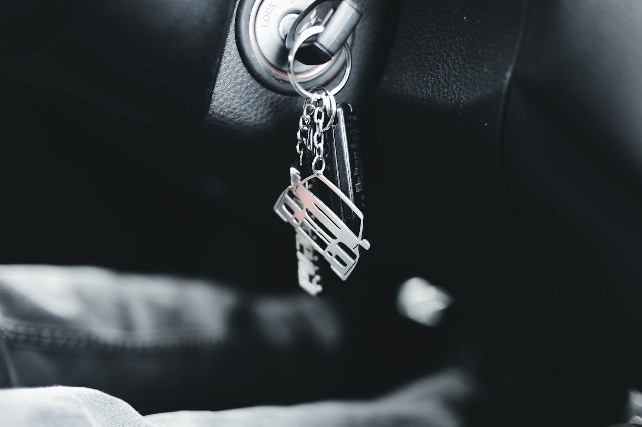 Close-up image of car keys in ignition, showcasing a silver car keychain. Ideal for automotive themes.